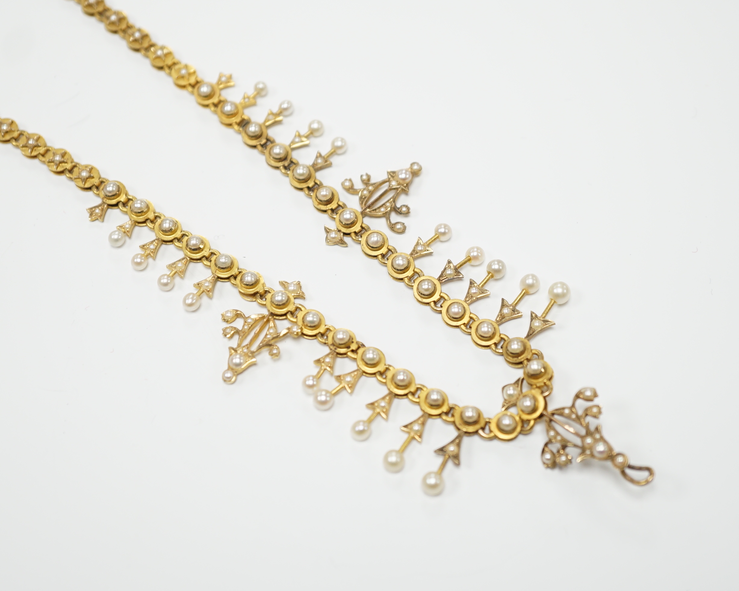 An Edwardian yellow metal and seed pearl set necklace, lacking drops and clasp, 39cm, gross weight 26.2 grams.